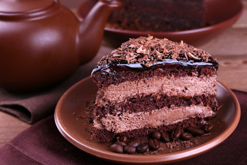 Delicious chocolate cake with coffee beans on plate on table close up