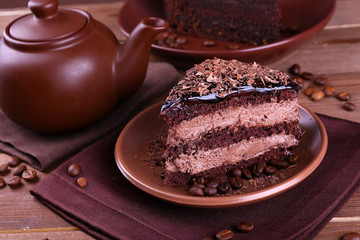 Delicious chocolate cake with coffee beans on plate on table close up
