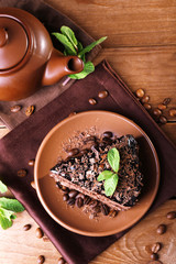 Delicious chocolate cake with mint on plate on table close up