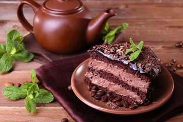 Delicious chocolate cake with mint on plate on table close up