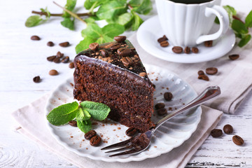 Delicious chocolate cake with mint on plate on table close up