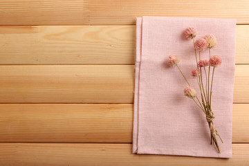 Fototapeta na wymiar Beautiful dry flowers on napkin on wooden background