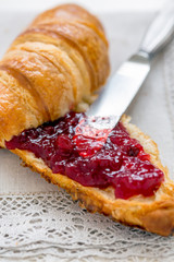 Croissant with jam for breakfast.