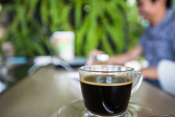 cup of coffee with man use laptop background