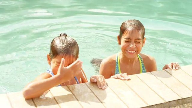 Young Hispanic girls smiling in a pool