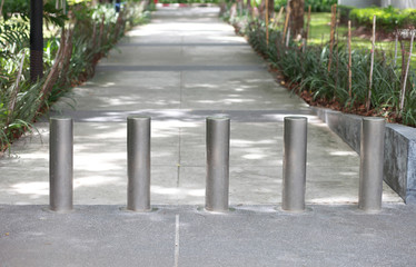 Steel barrier on the sidewalk in the park.