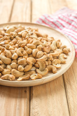 Salty cashew nuts in wooden plate