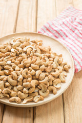 Salty cashew nuts in wooden plate