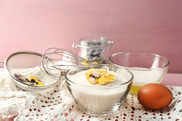 Making candied violet flowers with egg whites and sugar, on color wooden background