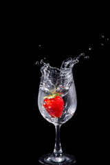 Strawberry in wine glass  on a black background