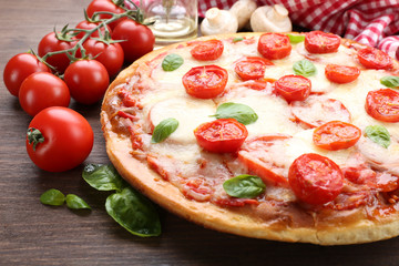 Delicious pizza with cheese and cherry tomatoes on wooden table, closeup
