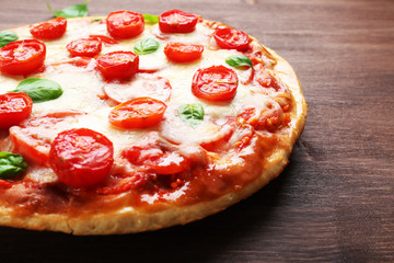Delicious pizza with cheese and cherry tomatoes on wooden table, closeup
