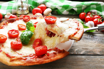 Delicious pizza with cheese and cherry tomatoes on wooden table, closeup