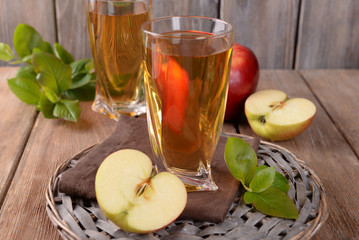 Glasses of apple juice on wooden background