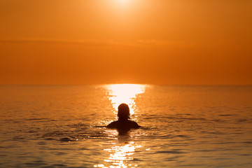 Man in Water on a sea in a sunrise