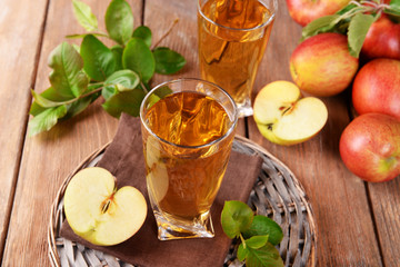 Glasses of apple juice on wooden table, closeup