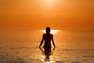 Fototapeta na wymiar Man in Water on a sea in a sunrise