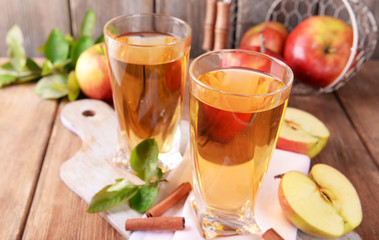 Glasses of apple juice on wooden table, closeup