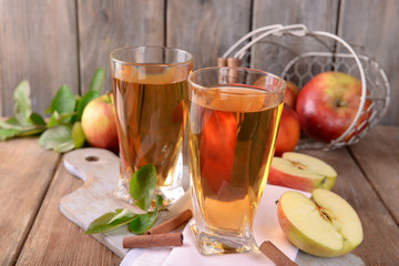 Glasses of apple juice on wooden background