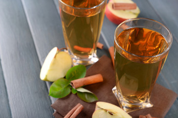 Glasses of apple juice on wooden table, closeup