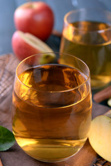 Glasses of apple juice on wooden table, closeup