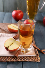 Glass of apple juice on wooden table, closeup