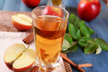 Glass of apple juice on wooden table, closeup