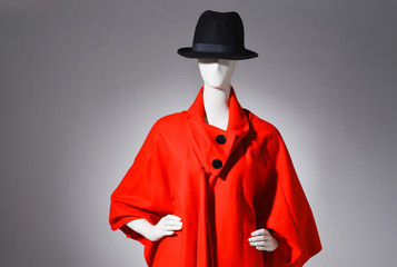female red coat with black hat on mannequin on gray background