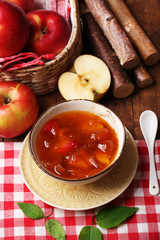Apple jam and fresh red apples on wooden table close-up
