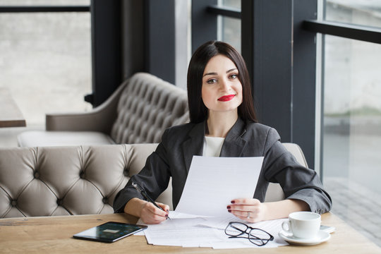 Businesswoman with documents and pen.