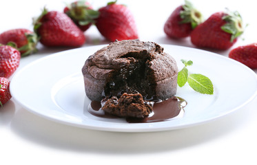 Chocolate fondant with strawberries on white plate, closeup