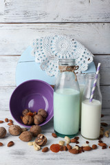 Milk in glassware and walnuts on background