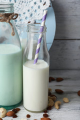 Milk in glassware and walnuts on background