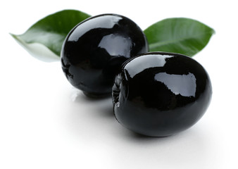 Black olives with leaves isolated on white