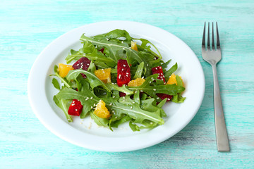Tasty salad with arugula leaves in plate on wooden table, closeup