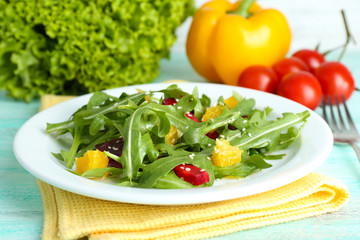 Tasty salad with arugula leaves in plate on wooden table, closeup