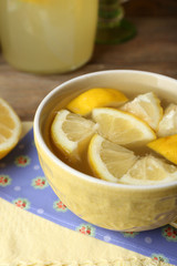 Naklejka na ściany i meble Still life with lemon juice and sliced lemons on wooden table with napkin, closeup