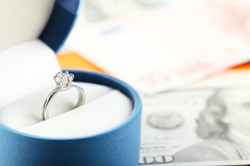Wedding ring in box  on banknotes background. Marriage of convenience