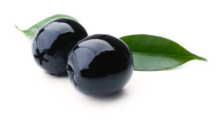 Black olives with green leaves isolated on white