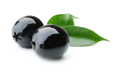 Black olives with green leaves isolated on white