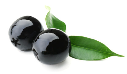 Black olives with green leaves isolated on white
