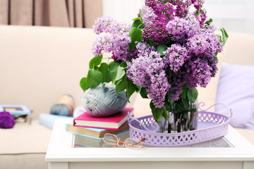 Beautiful lilac flowers in vase on table of interior background