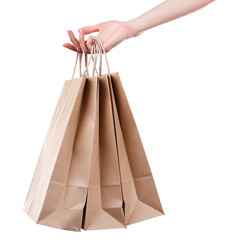 Female hand holding paper shopping bag isolated on white