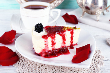 Tasty piece of cheesecake with berry sauce on plate on table close up