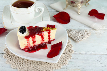 Tasty piece of cheesecake with berry sauce on plate on table close up