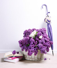 Beautiful lilac flowers with umbrella on floor in room close-up