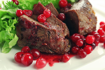 Tasty roasted meat with cranberry sauce on plate, close-up