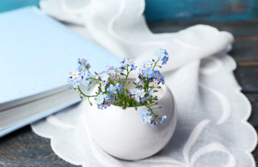 Composition with Forget-me-nots flowers on wooden background