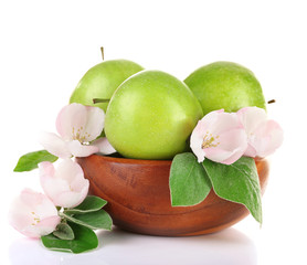 Fresh apples with apple blossom in wooden bowl, isolated on white
