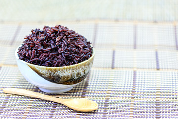 Rice berry in bowl with wooden spoon.